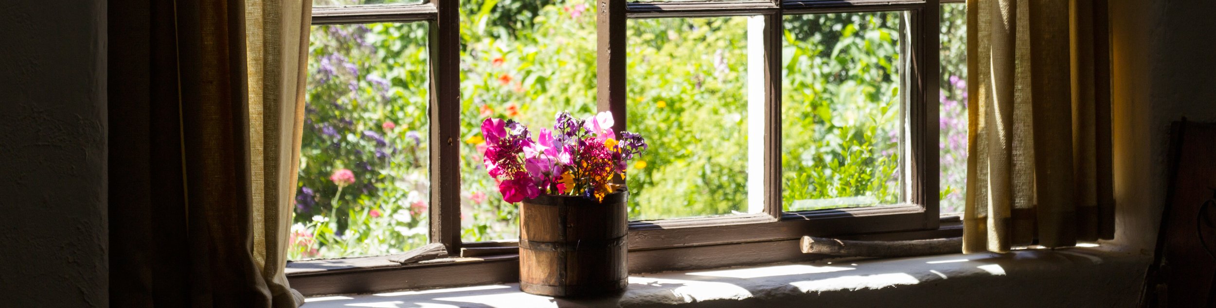 Cottage garden of small brick home Garden through window